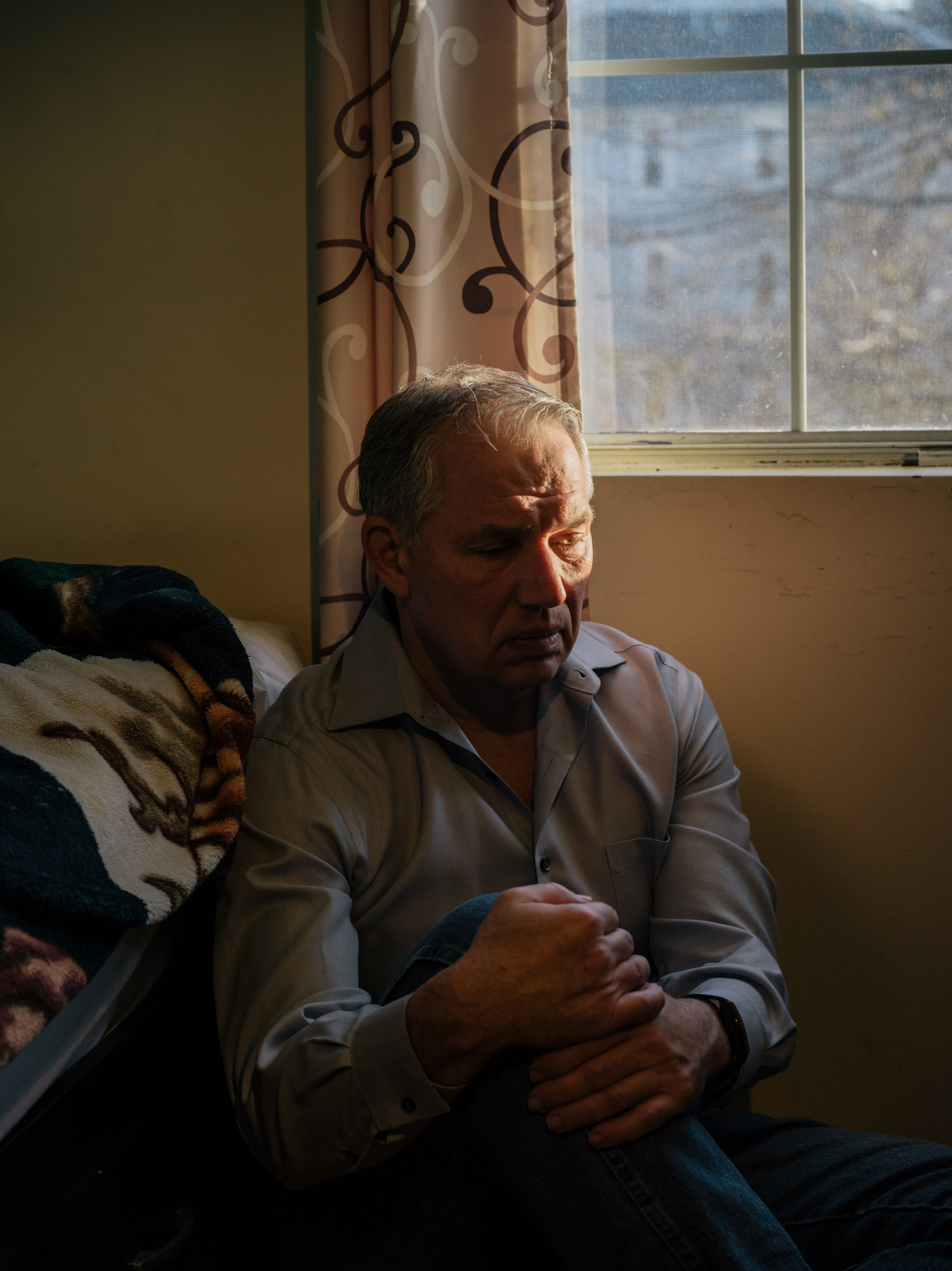 portrait of man next to window sunlight