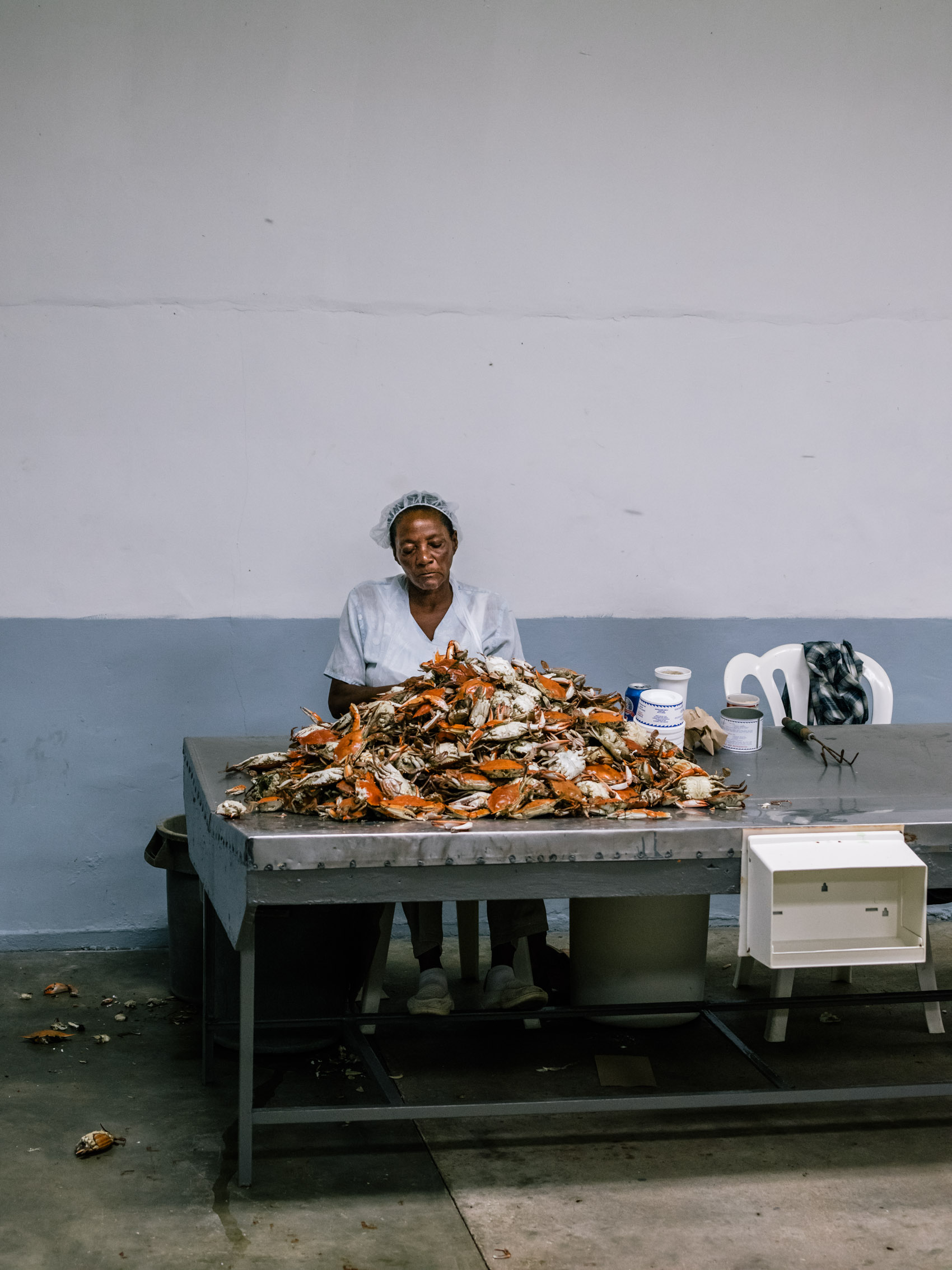 woman with pile of crabs to pick for meat at seafood house
