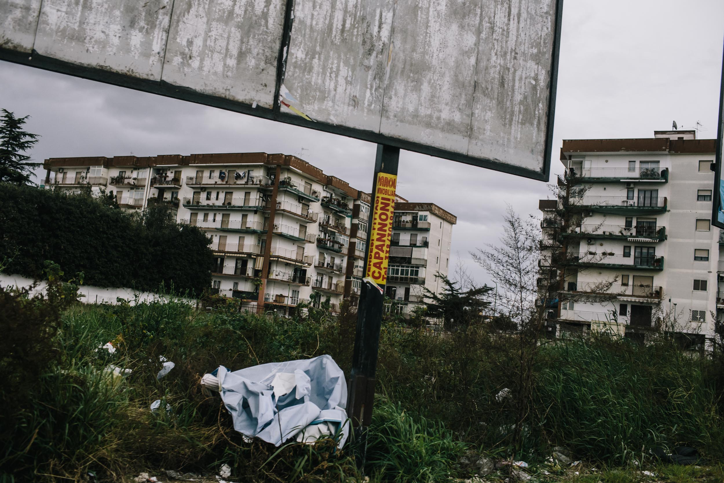 Scraps of packaging rest beneath a billboard in Giugliano Italy
