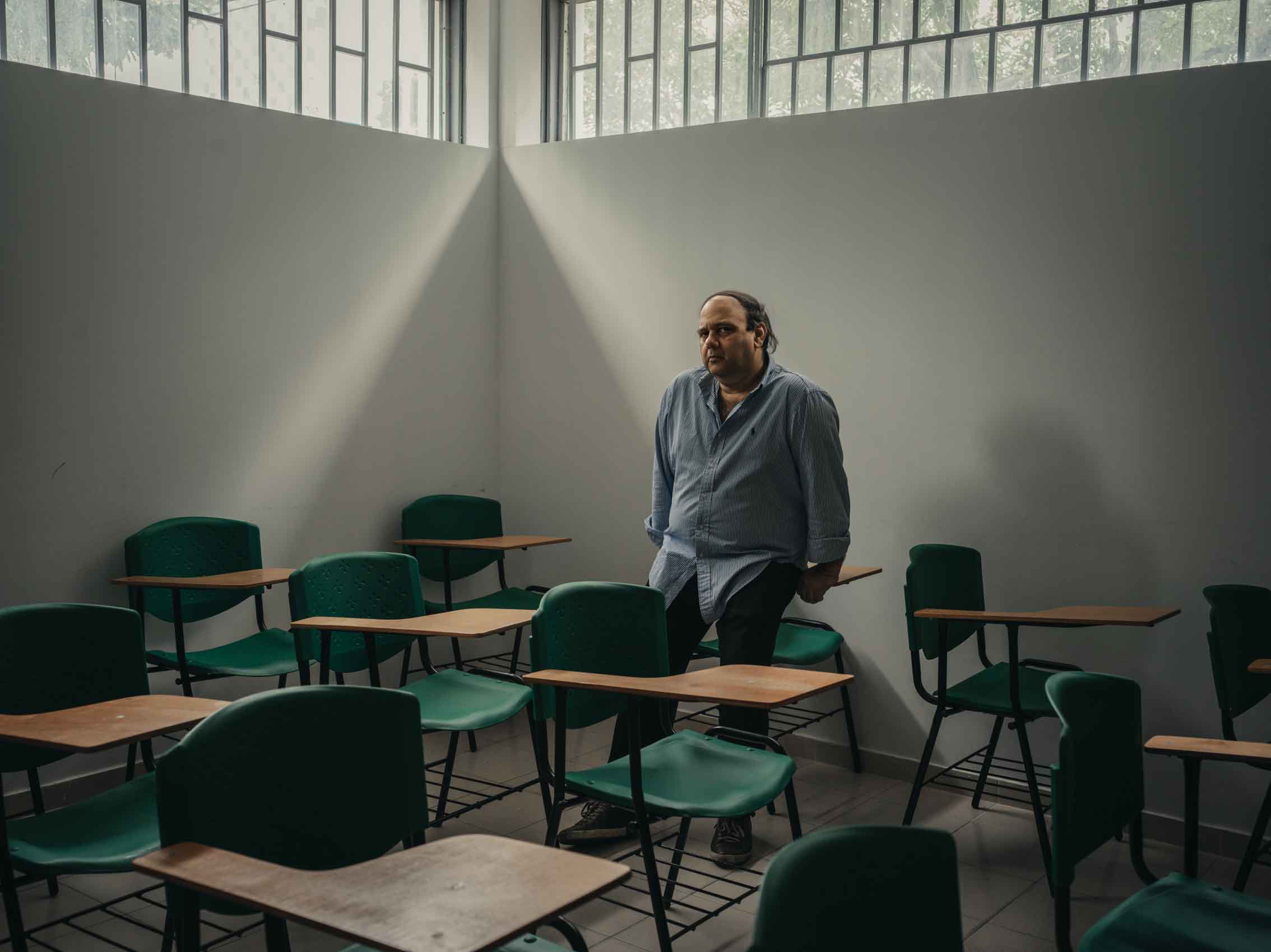 professor in classroom with empty desks