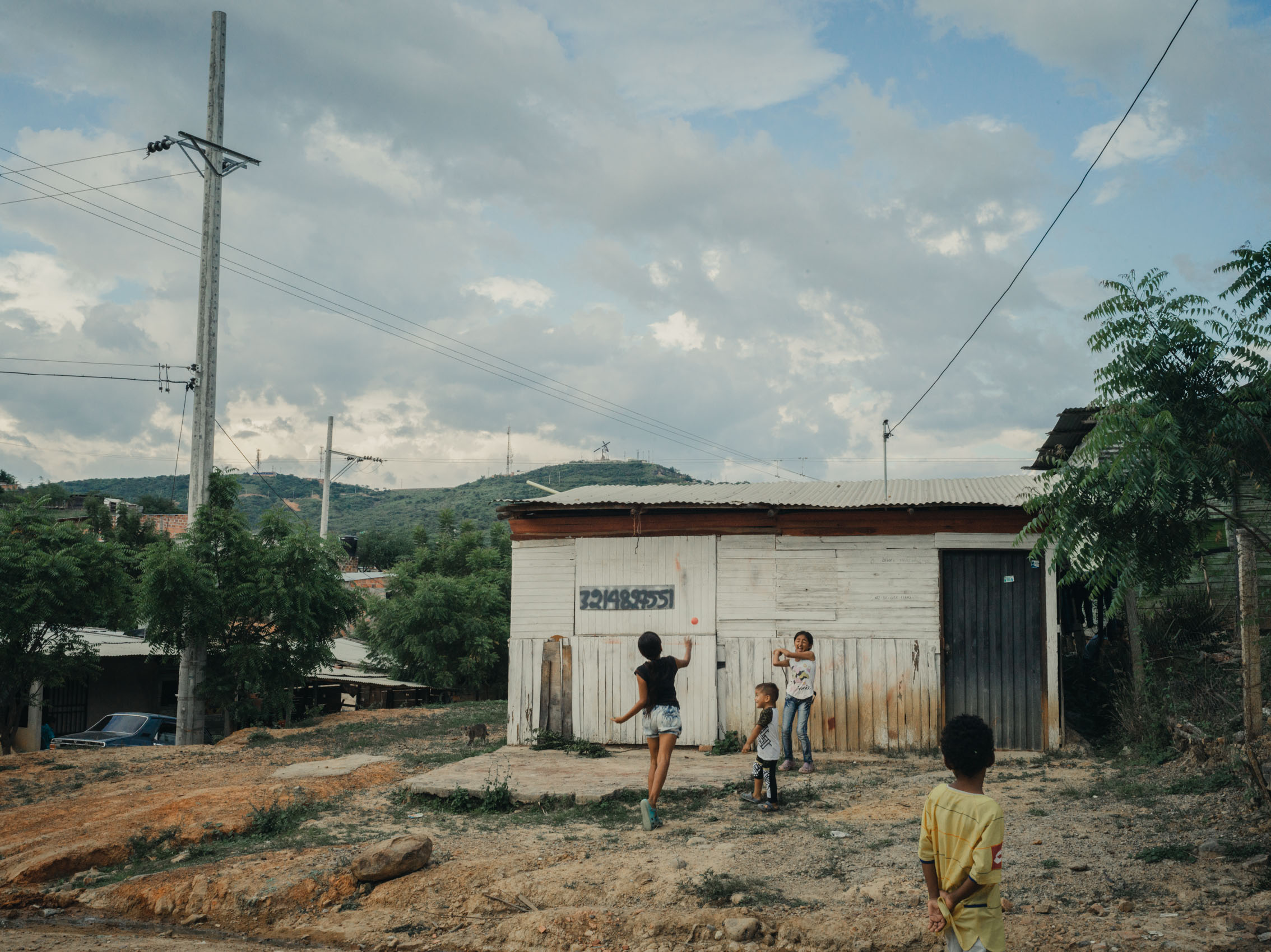 kids playing ball near homes in migrant neighborhood