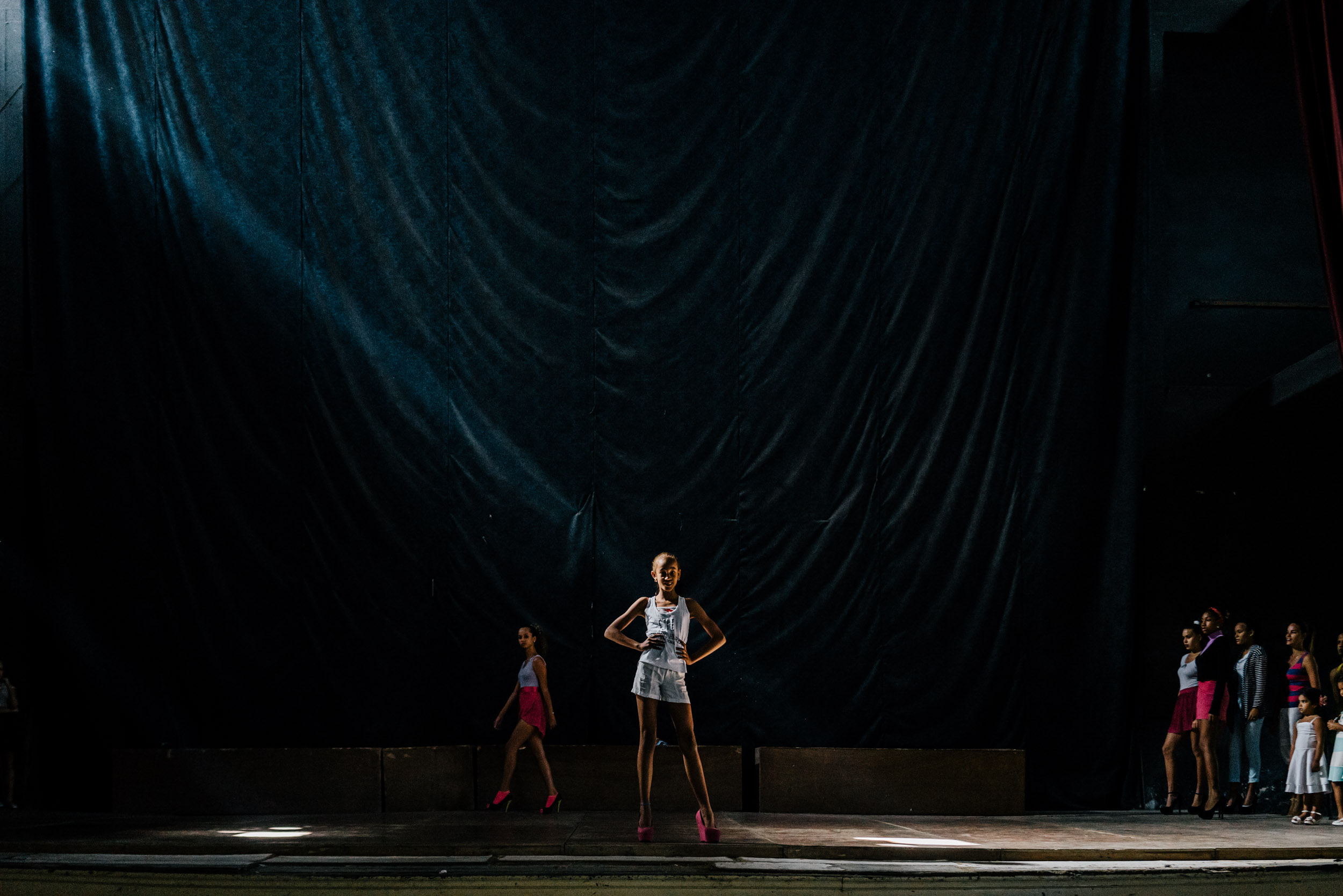 Modeling school attendees strut and pose on stage at the Teatro Municipal in Havana