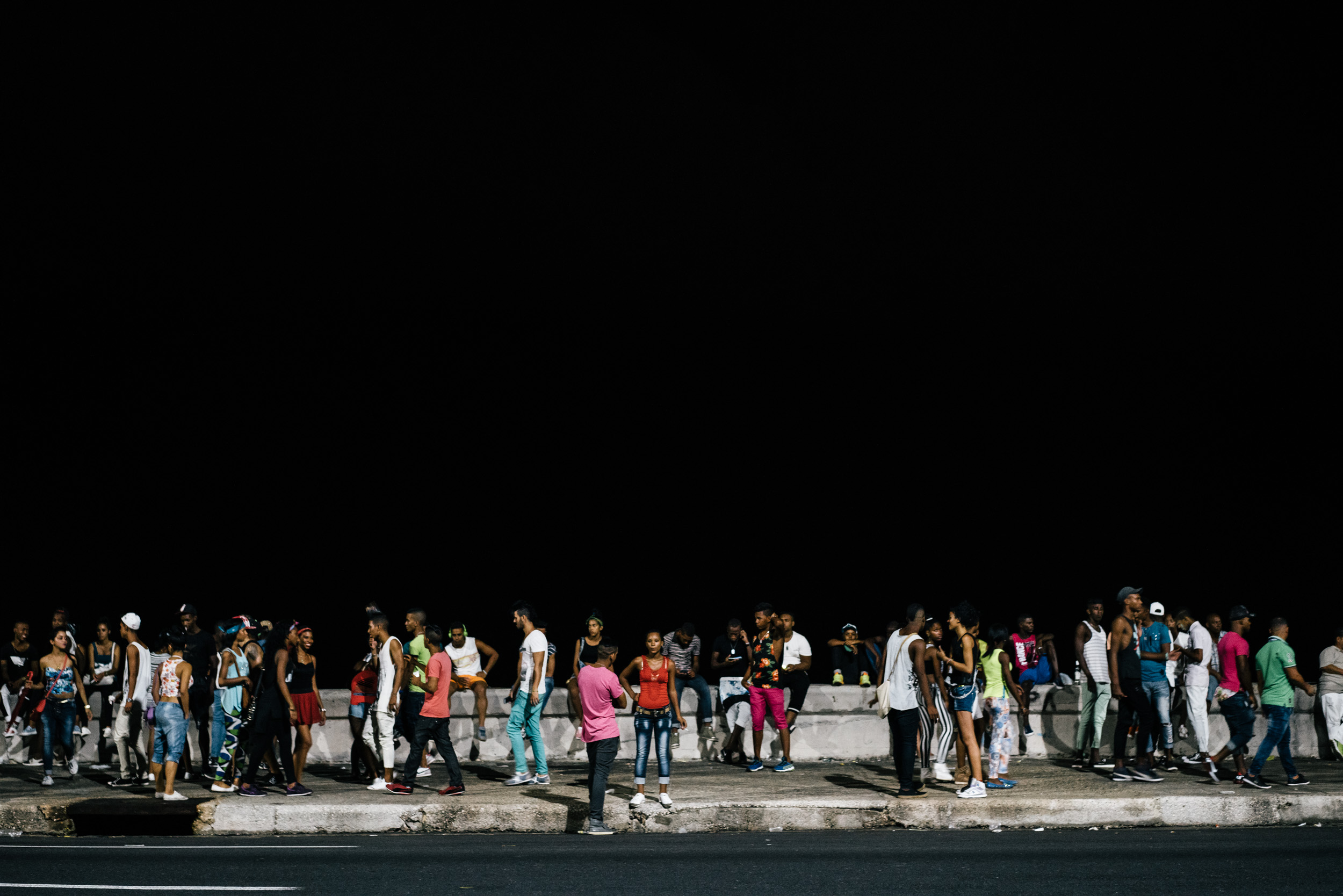 people partying at night along the Malecón in Havana