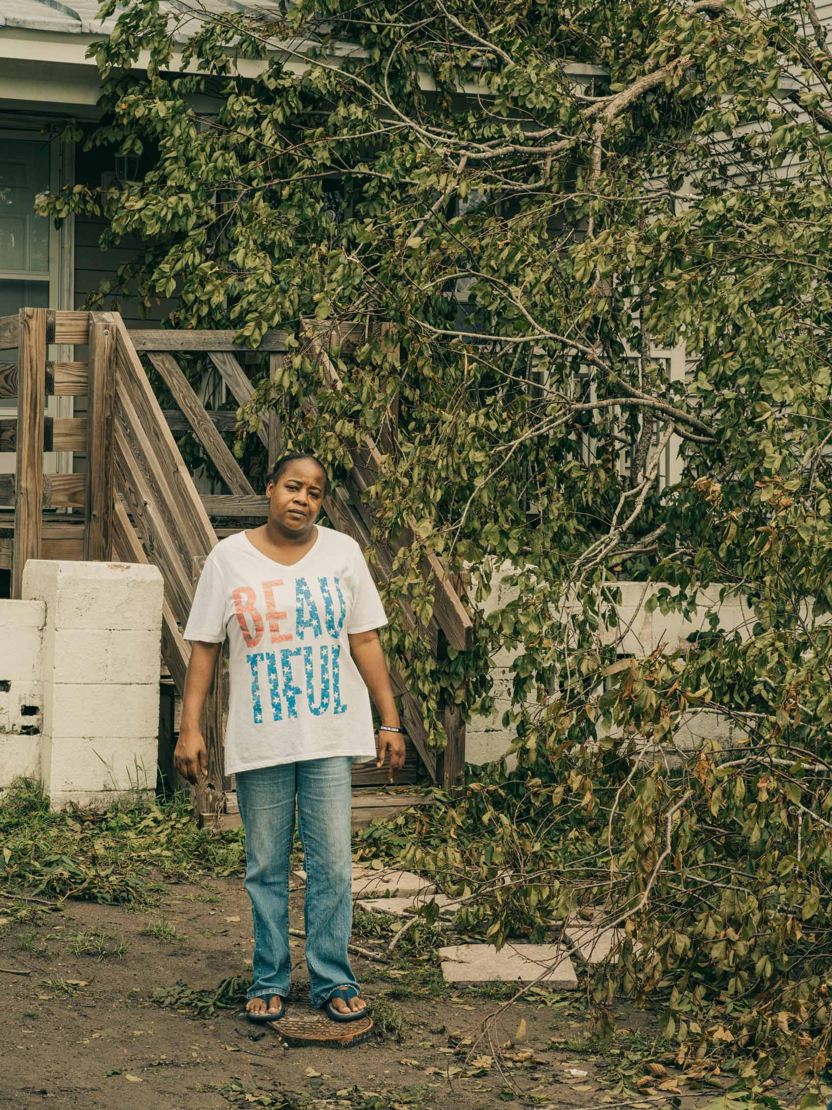 portrait of woman outside house with fallen tree