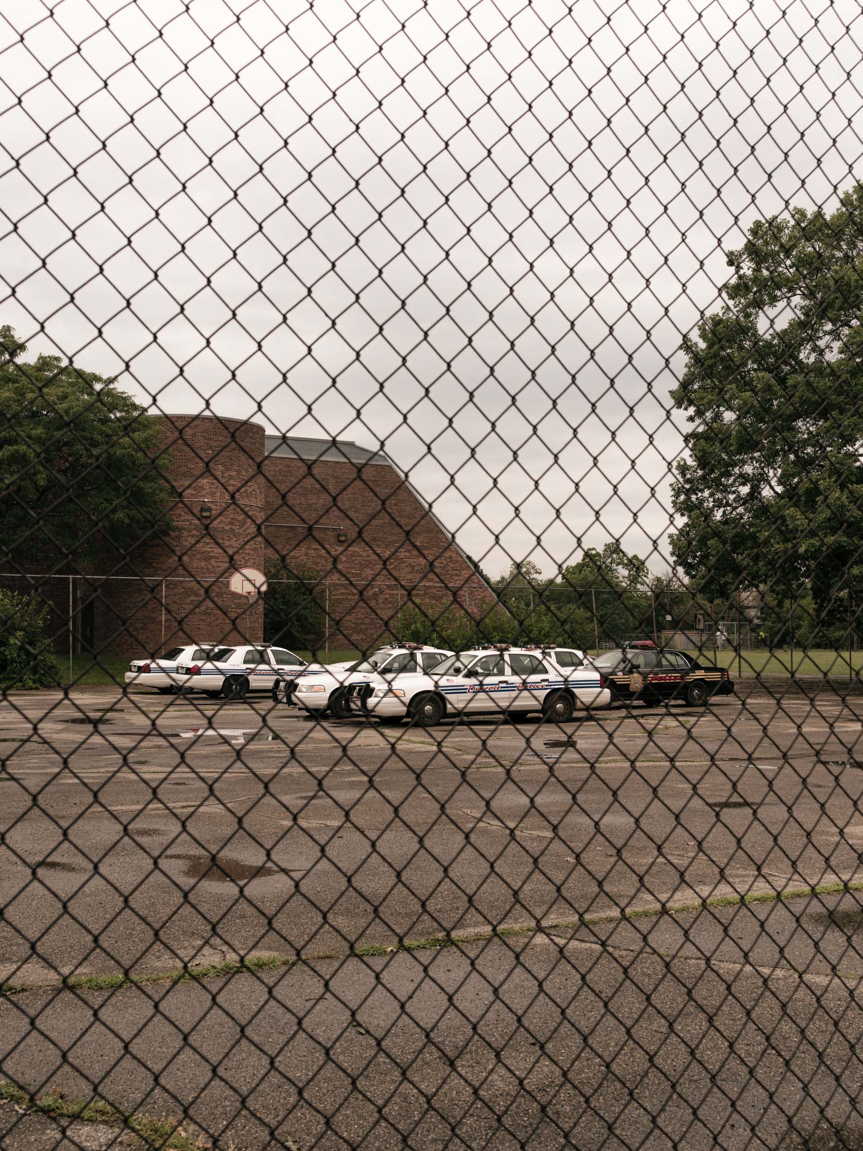 police cars behind chainlink fence