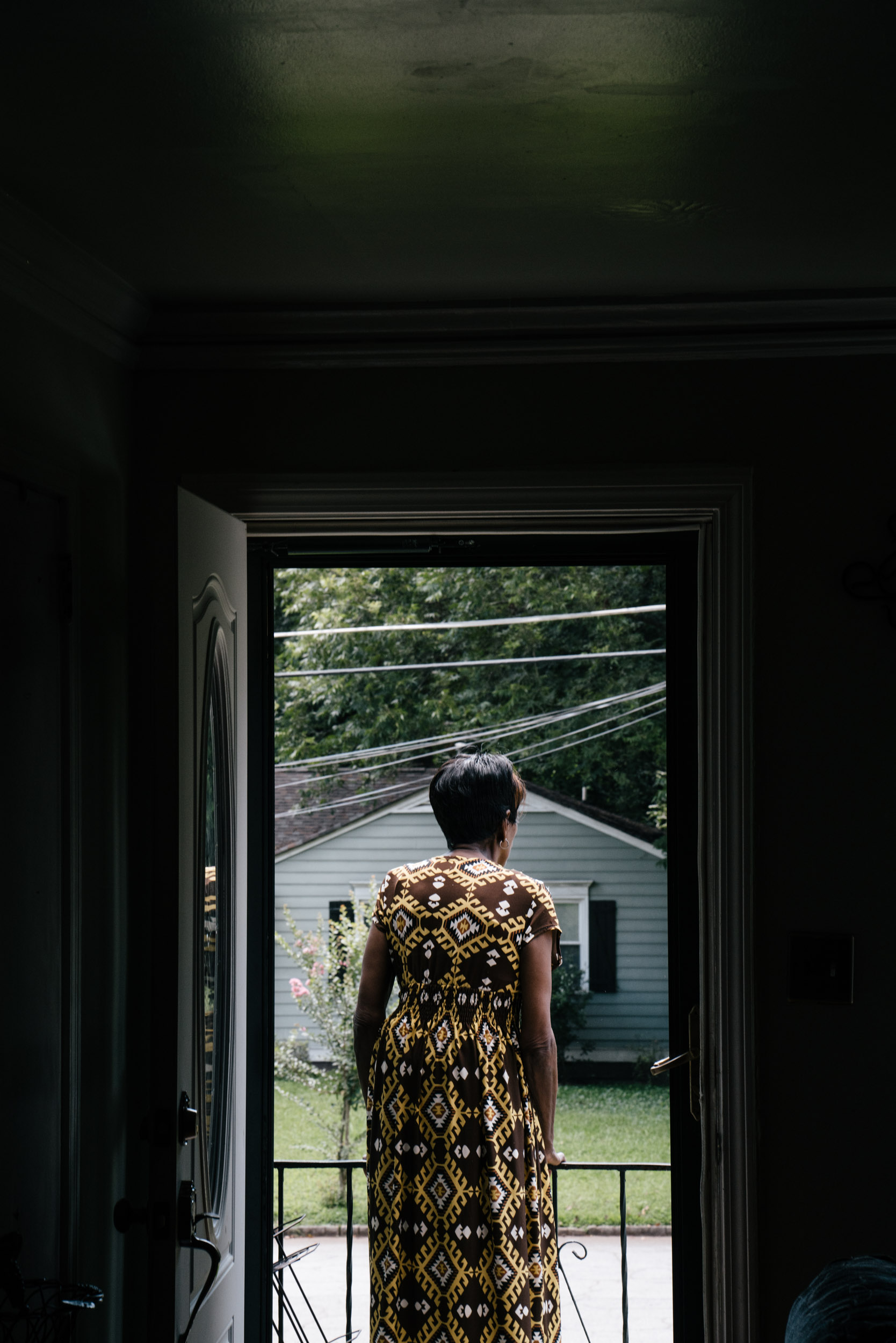 woman seen in doorway looking out at her neighborhood